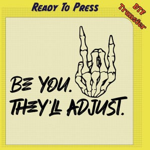 May include: DTF transfer with a yellow background and a black skeleton hand making a rock and roll gesture. The text "BE YOU. THEY'LL ADJUST." is written in black, with "READY TO PRESS" and "DTF Transfer" in the corners.