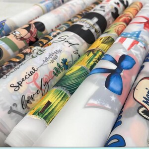 a collection of colorful, patterned fabric rolls or sheets, each with unique designs and text printed on them.
