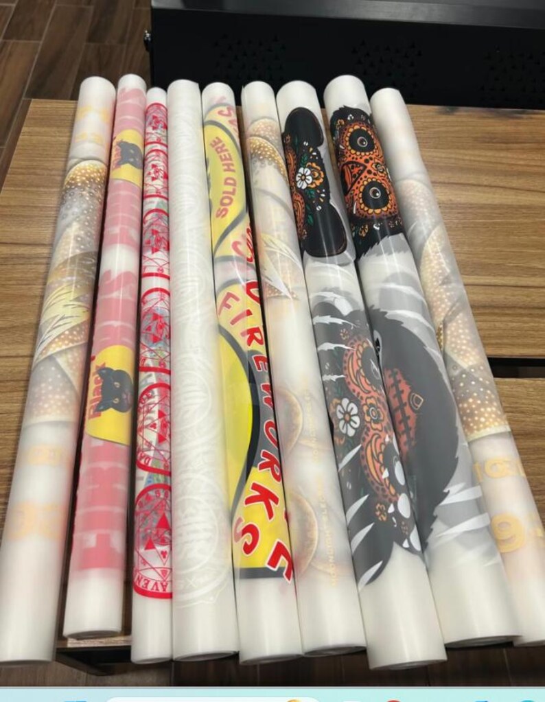 a collection of colorful, patterned, and textured rolls of paper or fabric, arranged on a wooden surface.