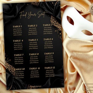 May include: Black and gold event seating chart with the text "Find Your Seat". The chart lists table numbers and guest names. A white masquerade mask rests on a gold satin surface.
