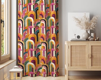May include: A colorful curtain with a repeating geometric pattern of arched shapes in shades of yellow, orange, pink, purple, and green. The curtain is hanging in front of a window, and a wooden cabinet with a vase of dried flowers is visible.