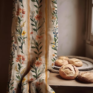 Può includere: Una tenda in tessuto beige con strisce verticali e un motivo floreale ripetuto nei toni dell'arancione, giallo, verde e blu. Il tessuto presenta una stampa botanica con steli, foglie e fiori disposti in colonne lungo tutto il materiale.