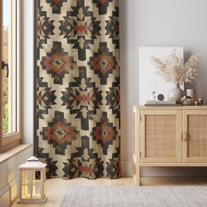 Könnte beinhalten: Ein beiger Vorhang mit einem geometrischen Muster in Schwarz, Rot und Braun hängt in der Nähe eines Fensters. Das Design des Vorhangs weist sich wiederholende Formen auf. Ein Holzschrank mit gewebter Front und Dekorationsartikeln steht daneben.