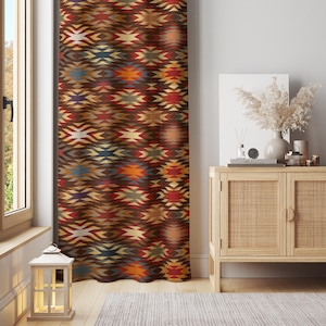 May include: A decorative curtain with a geometric pattern in shades of brown, red, orange, and blue. The curtain hangs in front of a window, adding a touch of color and design to the room. The pattern is a repeating design of diamond and arrow shapes.