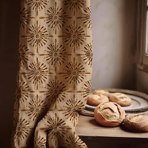 Può includere: Tenda in tessuto beige con un motivo ripetuto di disegni a stella marroni e dorati. Diverse pagnotte di pane rotonde sono su una superficie di legno vicino a una finestra.