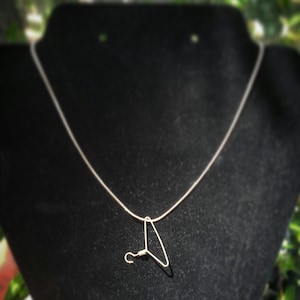 May include: A silver chain necklace with a small silver hanger pendant.