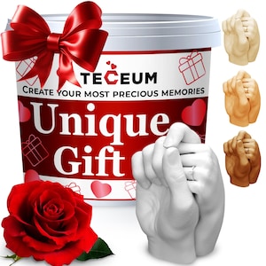 May include: A white container with the text "TECEUM" and "Unique Gift" on a red background. A large red bow and a red rose are in the image. Several hand-holding sculptures are shown in different colors.