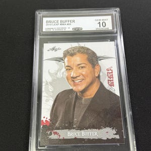 May include: A graded trading card featuring Bruce Buffer from the 2010 Leaf MMA series. The card is encased in a protective holder and graded as Gem Mint 10. The card has a portrait of Bruce Buffer.
