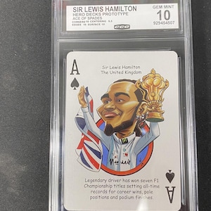 May include: A white ceramic mug with a black handle and the text "But First, Coffee" in a black, handwritten-style font. The mug is on a white surface.