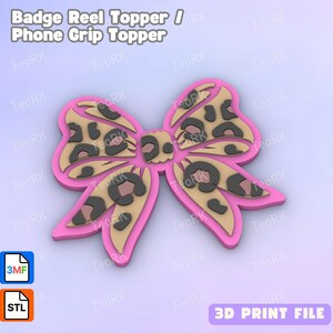 Pode incluir: Um acessório rosa em forma de laço para porta-crachá ou suporte de telefone, com um design de estampa de leopardo. O laço tem um contorno rosa e um fundo bege com manchas pretas. O texto "Badge Reel Topper / Phone Grip Topper" está no topo.