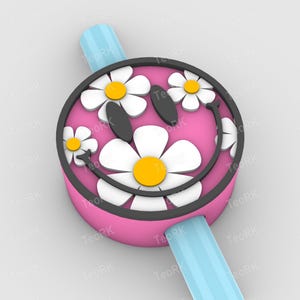 May include: A pink watch face with a black border and a daisy design. The daisies have white petals and yellow centers. The watch band is light blue.