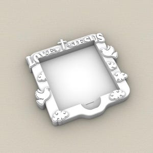 May include: White picture frame with the words "LOVE JESUS" in a decorative font. The frame features a cross, heart, doves, and cloud accents. The frame is square with a rounded bottom edge.