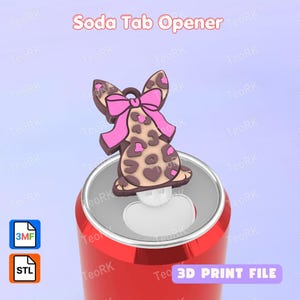 Pode incluir: Um abridor de latas em forma de animal com estampa de leopardo marrom e bege e um laço rosa brilhante, fixado no topo de uma lata vermelha. A imagem inclui o texto Soda Tab Opener e 3D PRINT FILE, com ícones de arquivos 3MF e STL.
