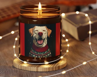 Puede incluir: Una vela encendida en un tarro de cristal marrón con un posavasos de madera. La etiqueta presenta un perro sonriente con un jersey navideño y una nariz roja. El fondo incluye una guitarra y luces de hadas.