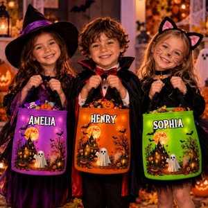May include: Three children in Halloween costumes holding light-up trick-or-treat buckets. The purple bucket is labeled Amelia, the orange bucket is labeled Henry, and the green bucket is labeled Sophia. Each bucket features a haunted house graphic.