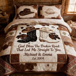 Könnte beinhalten: Ein Bettwäsche-Set im Landhausstil mit einer Steppdecke und zwei Kissenbezügen. Die Steppdecke zeigt ein Design mit Cowboy-Stiefeln und -Hüten, mit dem Text "God Bless The Broken Road That Led Me Straight To You Michael & Emma Est. 2004". Die Kissenbezüge zeigen Cowboyhüte.