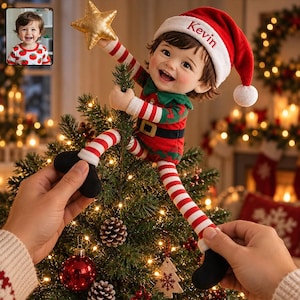 Könnte beinhalten: Eine Plüsch-Elfenpuppe mit rot-weiß gestreiftem Outfit, grünem Kragen und schwarzem Gürtel, die eine rote Weihnachtsmannmütze mit dem eingestickten Namen Kevin trägt. Die Puppe hält einen goldenen Stern auf einem grünen Weihnachtsbaum mit Lichtern.