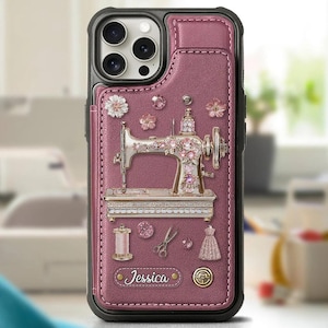May include: A mauve leather phone case featuring a decorative sewing machine, flowers, and sewing-themed details. The case includes a cardholder and the name "Jessica" is printed on the case.