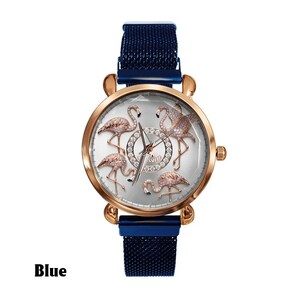 May include: A rose gold watch with a silver face featuring five flamingo designs. The watch has a blue mesh band and the word "Blue" is printed at the bottom. The watch face is surrounded by a rose gold bezel.