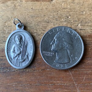 K&ouml;nnte beinhalten: Silberner Anh&auml;nger mit einer Darstellung der Heiligen C&auml;cilia, die eine Harfe h&auml;lt, mit dem Text "St. Cecilia Pray for Us" am Rand. Der Anh&auml;nger liegt neben einer US-Viertel-Dollar-M&uuml;nze zum Gr&ouml;&szlig;envergleich.