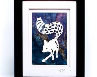 May include: A framed artwork featuring a white paper-cut silhouette of a fox against a dark blue, purple, and gold ink wash background. The fox has intricate patterns on its tail. The piece is enclosed in a black frame with a white mat board.