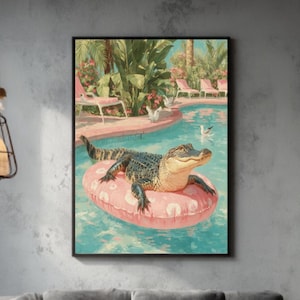 May include: A framed art print shows an alligator on a pink inflatable ring in a swimming pool. The artwork has a retro style, with a tropical resort scene in the background. The room features a grey sofa, wooden coffee table, and a large window.
