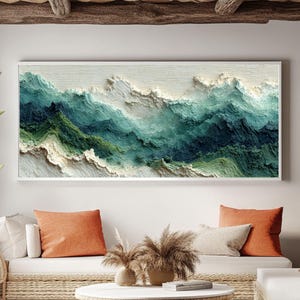 以下が含まれることがあります： 緑と青の色合いで海の波を描いた、額入りの抽象芸術作品。白い壁に掛けられ、オレンジ色のクッションが付いた白いソファの上に飾られています。織りのコーヒーテーブルとラグが、海岸をテーマにしたリビングルームを完成させています。