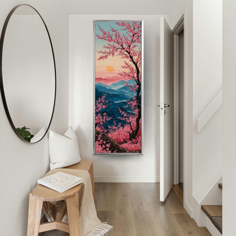 May include: A framed vertical art print showing a cherry blossom tree in full bloom against a backdrop of blue mountains and a sunset. The artwork uses pink and red tones to depict the sky and blossoms.
