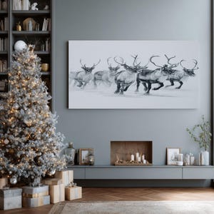 May include: A monochrome painting of reindeer in motion adorns a wall above a fireplace. A decorated Christmas tree with lights and baubles stands to the left, with wrapped presents beneath. The room has a modern, minimalist design with a grey colour scheme.