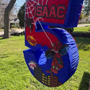 K&ouml;nnte beinhalten: Eine wei&szlig;e Keramik-Tasse mit schwarzem Henkel und dem Text "But First, Coffee" in fetter, schwarzer Schrift. Die Tasse steht vor einem verschwommenen Hintergrund, der eine gem&uuml;tliche Umgebung suggeriert.