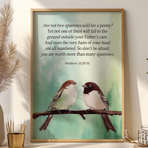 May include: Framed art print featuring two sparrows perched on a branch. The artwork has a watercolor background in shades of green and blue. Text from Matthew 10:29-31 is displayed above the birds, offering a message of faith and reassurance.
