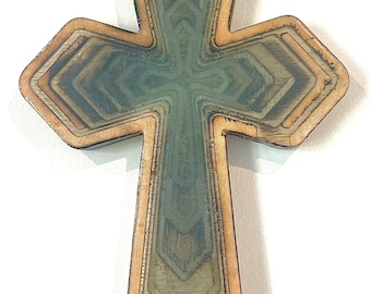 May include: Wooden cross with a layered design. The cross features a natural wood border and a central design with shades of green, brown, and yellow. The layered effect creates depth and dimension, suitable for religious decor.