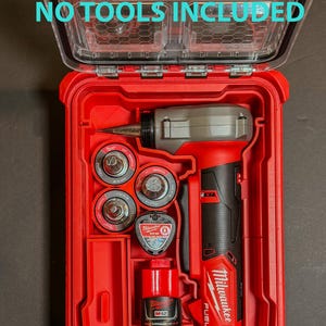 Pode incluir: Kit de ferramentas vermelho Milwaukee M12 FUEL com tampa transparente. O kit contém uma ferramenta elétrica vermelha e preta, vários acessórios e uma bateria. O texto "NO TOOLS INCLUDED" é visível na tampa.