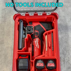 Può includere: Valigetta per utensili Milwaukee rossa con coperchio trasparente, contenente un elettroutensile nero e rosso, una batteria e accessori. Il testo "NO TOOLS INCLUDED" è visibile sul coperchio. La valigetta è progettata per riporre e organizzare gli utensili.