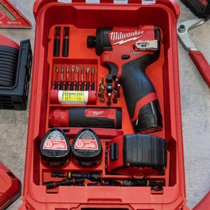 May include: Red tool case with various tools, including a drill, bits, and batteries. The case is open, revealing the tools neatly organized inside. The text "NO TOOLS INCLUDED" is visible at the top.
