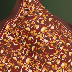 May include: A patterned scarf with a geometric design. The scarf features a repeating pattern of squares filled with quarter-circle shapes in shades of brown, yellow, and cream against a burgundy background. The scarf has a dark brown border.
