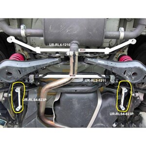 May include: A white automotive chassis reinforcement bar set installed on a vehicle undercarriage. The components are labeled UR-RL4-1210, UR-RL2-1211, and two UR-RLS4-823P bars. These white metal bars are positioned near the exhaust and red coil springs.