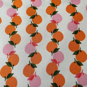 May include: White fabric with a repeating pattern of orange and pink citrus fruit. The fruit is stylized and has a green leaf stem.