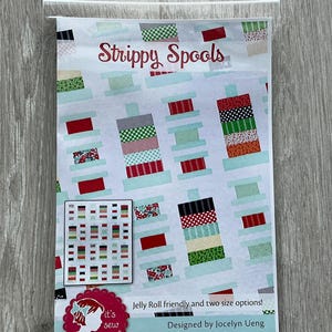 May include: A quilting pattern called "Strippy Spools" featuring a colorful design of stacked fabric strips. The pattern is Jelly Roll friendly and includes two size options. It's Sew Emma is the brand name.