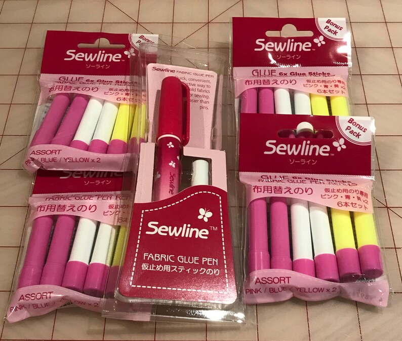 May include: Assortment of Sewline fabric glue sticks in pink, blue, and yellow. The packaging features the text "Sewline" and "Fabric Glue Pen" in Japanese and English. The glue sticks are labeled "Assort" and come in a pack of six.