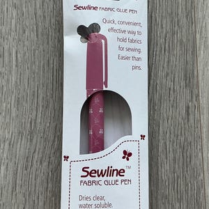 May include: A pink fabric glue pen with a butterfly design on the packaging. The packaging says "Sewline Fabric Glue Pen" and "Dries clear, water soluble".