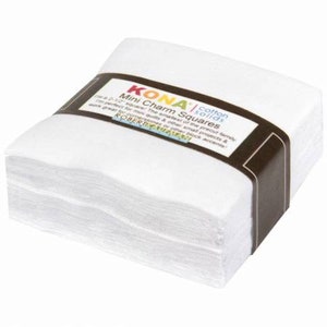 May include: A stack of white Kona cotton fabric squares, labeled "Mini Charm Squares" and "cotton solids". The label also includes the text "The smallest of the precut family - 2 1/2" squares. These squares are perfect for mini quilts & other small projects & work great for cornerstones or other block accents. ROBERT Kaufman"