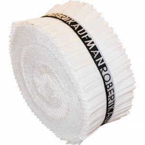 May include: A white fabric roll with a black label that reads "ROBERT KAUFMAN" in a circular pattern.