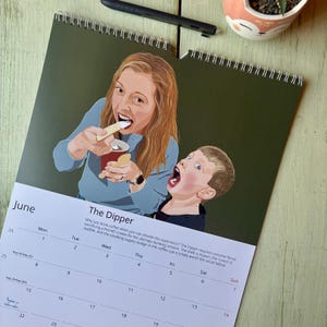 May include: A wall calendar for June titled The Dipper, featuring a digital illustration of a person with long brown hair in a blue shirt eating a cookie and a child with short brown hair in a black shirt, with text describing the dunking experience.
