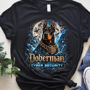 Może przedstawiać: Czarna koszulka z grafiką Dobermana z łańcuchem ze złota i wisiorkiem w kształcie kłódki. Projekt zawiera słowa "Doberman" i "Cyber Security" w futurystycznej czcionce, z pełnią księżyca i nietoperzami w tle.