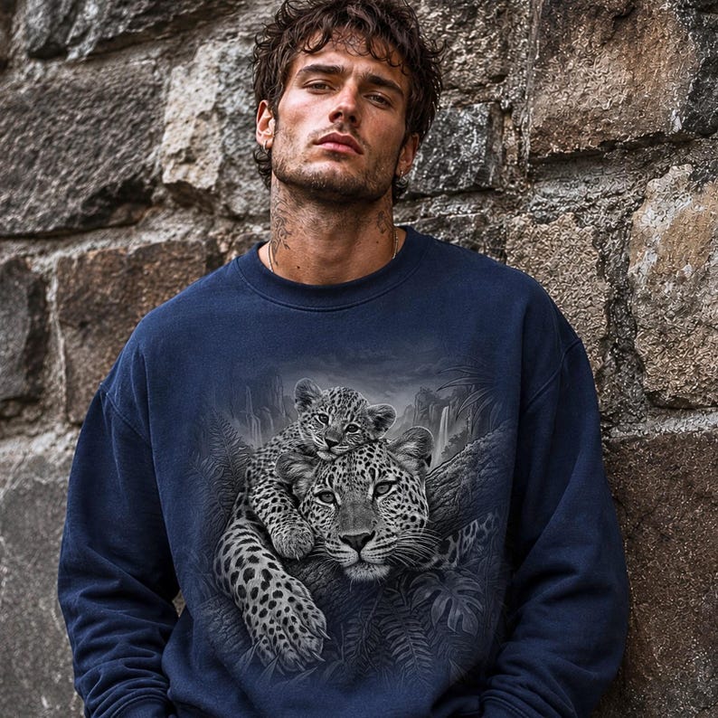 May include: A navy blue crewneck sweatshirt featuring a detailed black and white graphic print of a leopard resting with its cub in a jungle setting with foliage and a waterfall in the background, rendered in a realistic artistic style.