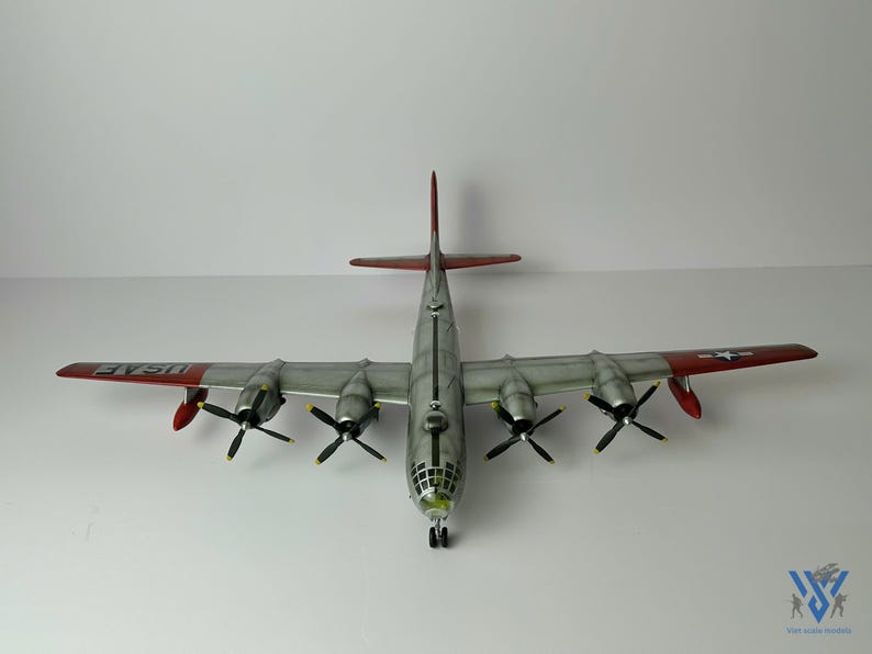 Pu&ograve; includere: Modello dettagliato di un aereo B-29 Superfortress, visto dall'alto. L'aereo ha quattro eliche, ali argentate con estremit&agrave; rosse e la scritta "USAF" sulle ali. Il modello &egrave; posto su uno sfondo bianco.