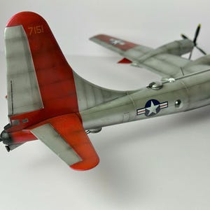 Pu&ograve; includere: Modello dettagliato di aereo con fusoliera argentata e coda rossa. La coda presenta il numero "7151" in bianco. Le ali hanno eliche e l'insegna a stella dell'US Air Force. Il modello &egrave; un aereo d'epoca.