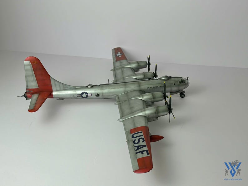 Pu&ograve; includere: Modello dettagliato di un bombardiere B-29 Superfortress argento e rosso. Il modello presenta quattro eliche, la scritta "UNITED STATES AIR FORCE" e le lettere "USAF" sulla coda. Le ali e la coda hanno accenti rossi.