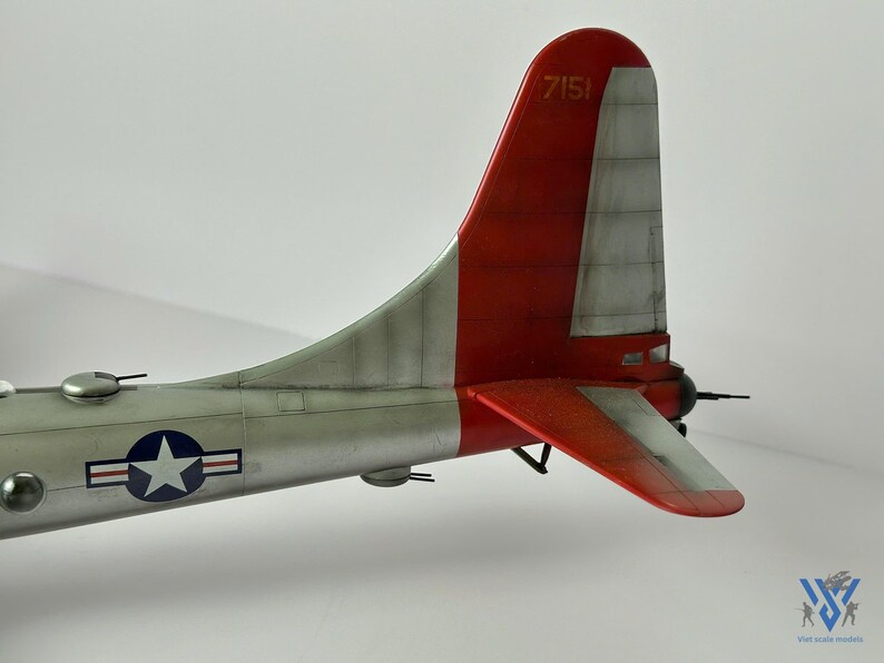 Pu&ograve; includere: Modello dettagliato di una sezione di coda di aereo, con schema di colori rosso e argento. La deriva ha il numero "7151" stampato sopra. Un emblema a stella blu e bianco &egrave; visibile sulla fusoliera. Il modello &egrave; ambientato su uno sfondo semplice.